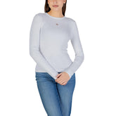 Image 1 : Femme portant un t-shirt blanc à manches longues côtelé Calvin Klein Jeans avec logo CK sur la poitrine, associé à un jean bleu — Delvale