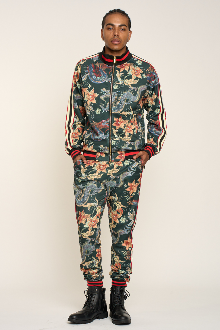 Person wearing a floral and camouflage patterned tracksuit on a white background