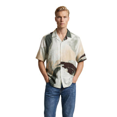 Image 1 : Homme portant la chemise manches courtes Only & Sons à imprimé aquarelle kaki et sable, col classique ouvert, avec un jean brut — Delvale
