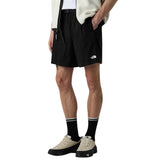 Image 1 : Bermuda homme The North Face noir porté de profil, avec logo brodé sur la cuisse, ceinture élastiquée et poches frontales — Delvale