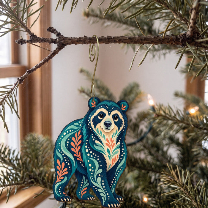 Laser-cut maple wood Andean Bear folk art ornament O369 hanging on a fir branch, made in USA