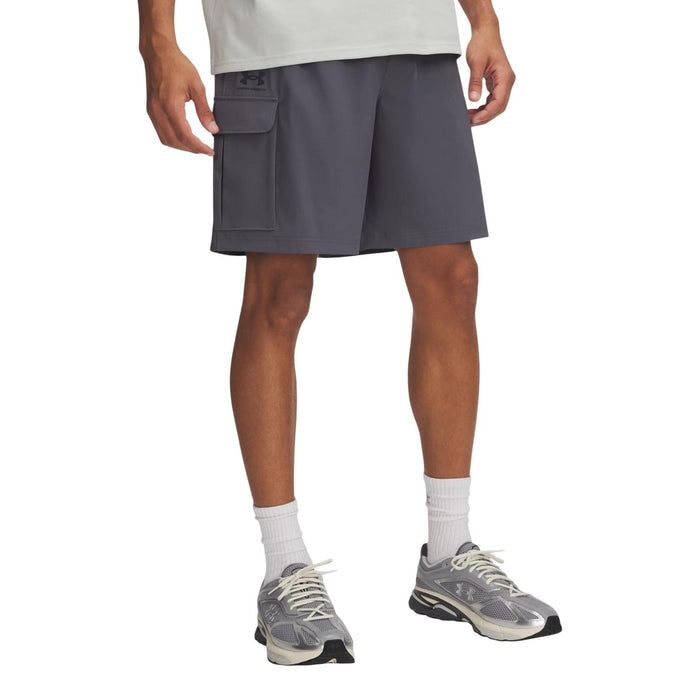 Bermuda cargo Under Armour homme gris porté de face, coupe ample au genou avec poche latérale à rabat et logo imprimé
