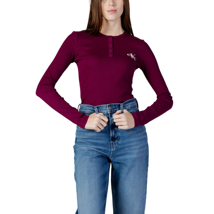Image 1 : Femme portant un t-shirt manches longues Calvin Klein Jeans bordeaux avec encolure henley et logo CK brodé, associé à un jean brut — Delvale