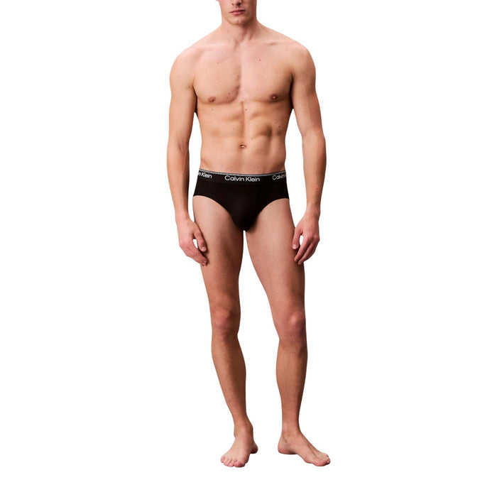 Image 5 : Trio de slips Calvin Klein Underwear homme noirs disposés en éventail superposé, ceintures logo visibles sur fond blanc — Delvale