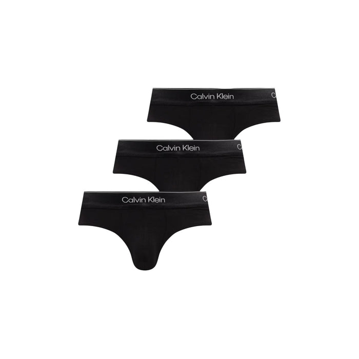 Image 7 : Lot de 3 slips Calvin Klein Underwear homme noirs photographiés légèrement en biais sur fond blanc épuré — Delvale