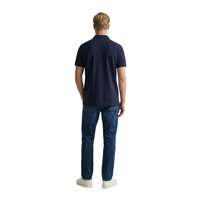 Image 3 : Vue de trois quarts du polo Gant Shield homme bleu marine, col polo structuré et patte de boutonnage visible — Delvale