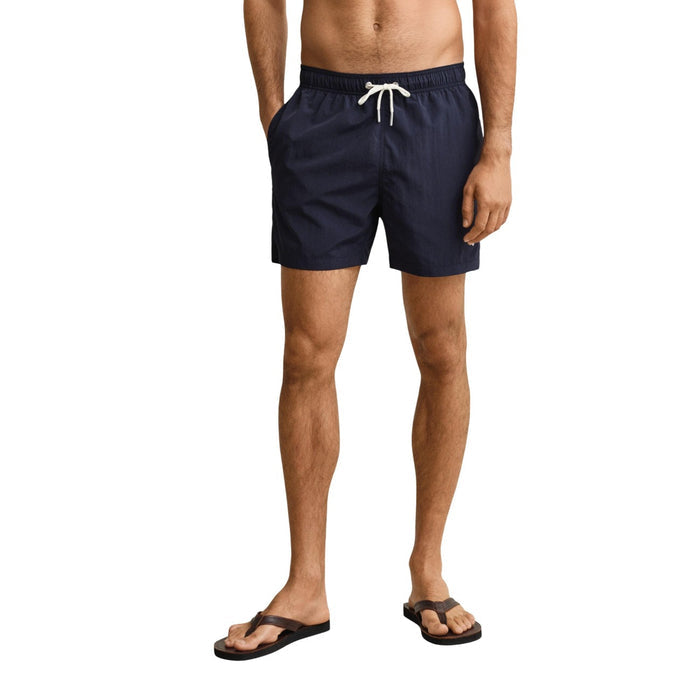 Image 1 : Short de bain Gant homme bleu marine uni avec cordon lacets blanc, porté de face, vue mi-corps — Delvale
