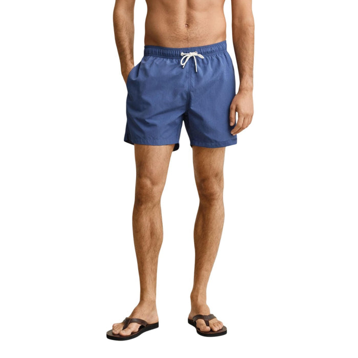 Image 5 : Short de bain Gant homme bleu marine, vue d'ensemble du modèle porté avec tongs marron — Delvale