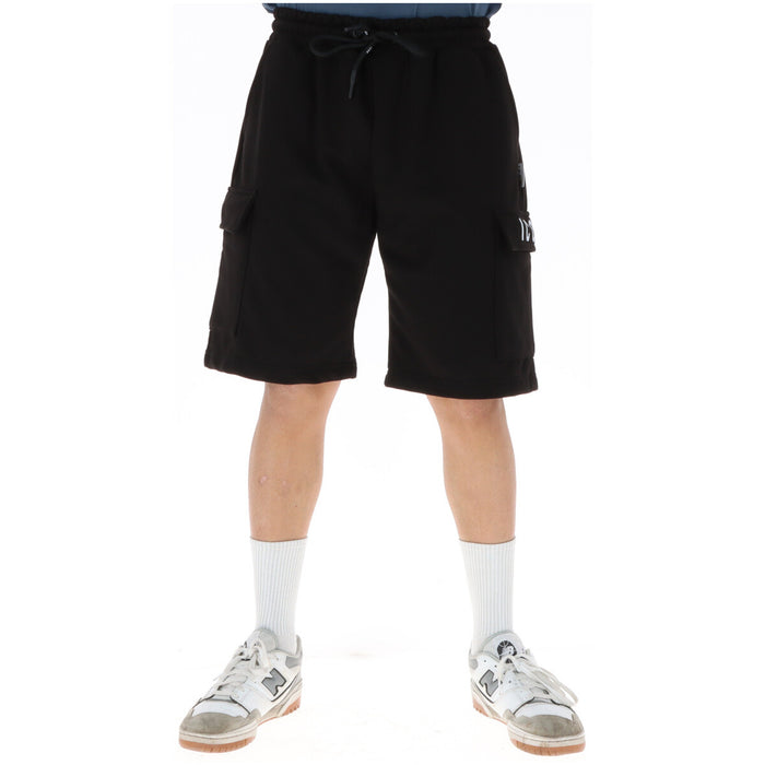 Image 1 : Bermuda cargo Icon homme noir en molleton, poches latérales à rabat et cordon de serrage, porté avec baskets New Balance blanches — Delvale
