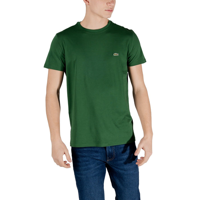 Image 1 : T-shirt Lacoste homme col rond vert avec logo crocodile brodé, porté sur un jean brut, vue de face trois quarts — Delvale