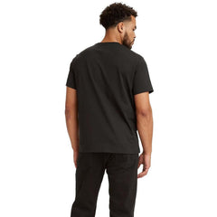 Image 2 : Vue de face du t-shirt Levi's® homme noir logo Batwing, coupe classique portée avec un pantalon noir — Delvale