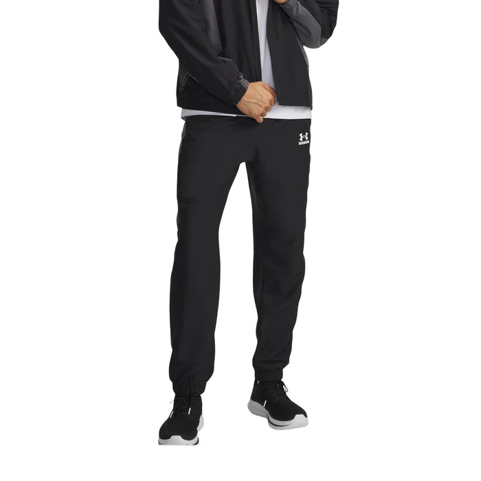 Pantalon technique Under Armour homme noir et gris porté de face avec veste assortie, coupe droite et chevilles resserrées