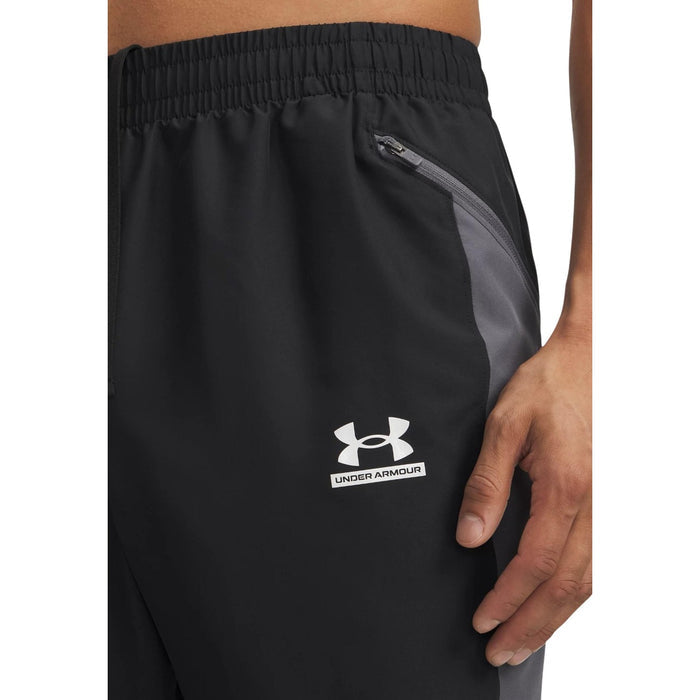 Détail poche zippée et insert gris du pantalon Under Armour homme noir, logo Under Armour imprimé sur la cuisse