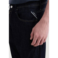 Image 3 : Jean slim homme Replay denim indigo, vue trois quarts basse, porté avec baskets blanches — Delvale