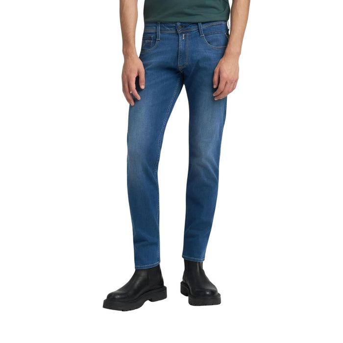Image 1 : Jean slim Replay homme en denim stretch bleu medium, vue de face portée avec boots noires — Delvale