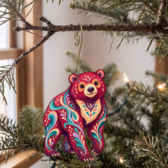 Laser-cut maple wood Sun Bear folk art ornament O368 hanging on a fir branch, made in USA