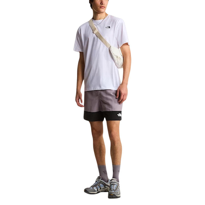 Image 2 : T-shirt The North Face homme blanc manches courtes porté avec un short gris — Delvale