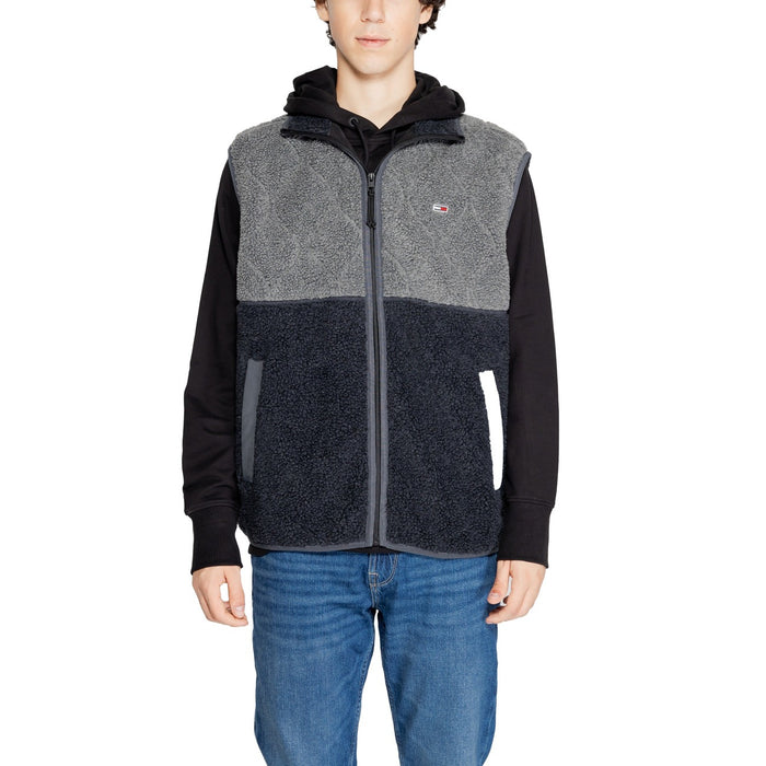 Image 1 : Gilet sherpa bicolore Tommy Hilfiger homme, coloris gris et marine, fermeture éclair, porté sur hoodie noir avec jean bleu — Delvale
